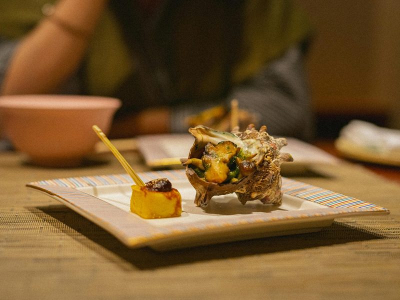 Exquisite seafood dish with shellfish and sauce, served in a Japanese setting. Perfect for gourmet dining experiences.